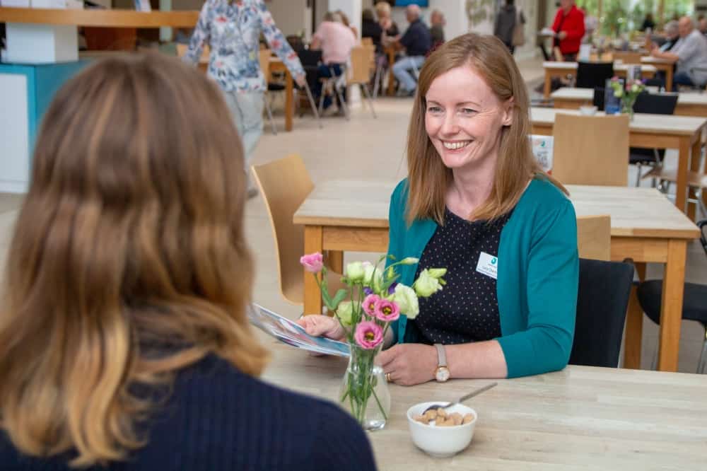 Two women sharing a drink in the hospice cafe