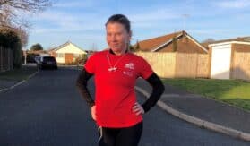 Elaine French in running gear standing on road