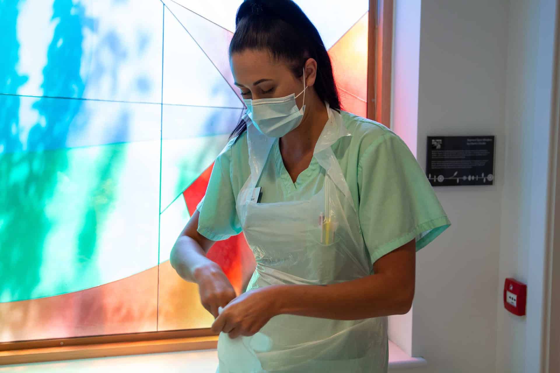 Nurse applying PPE in IPU at hospice