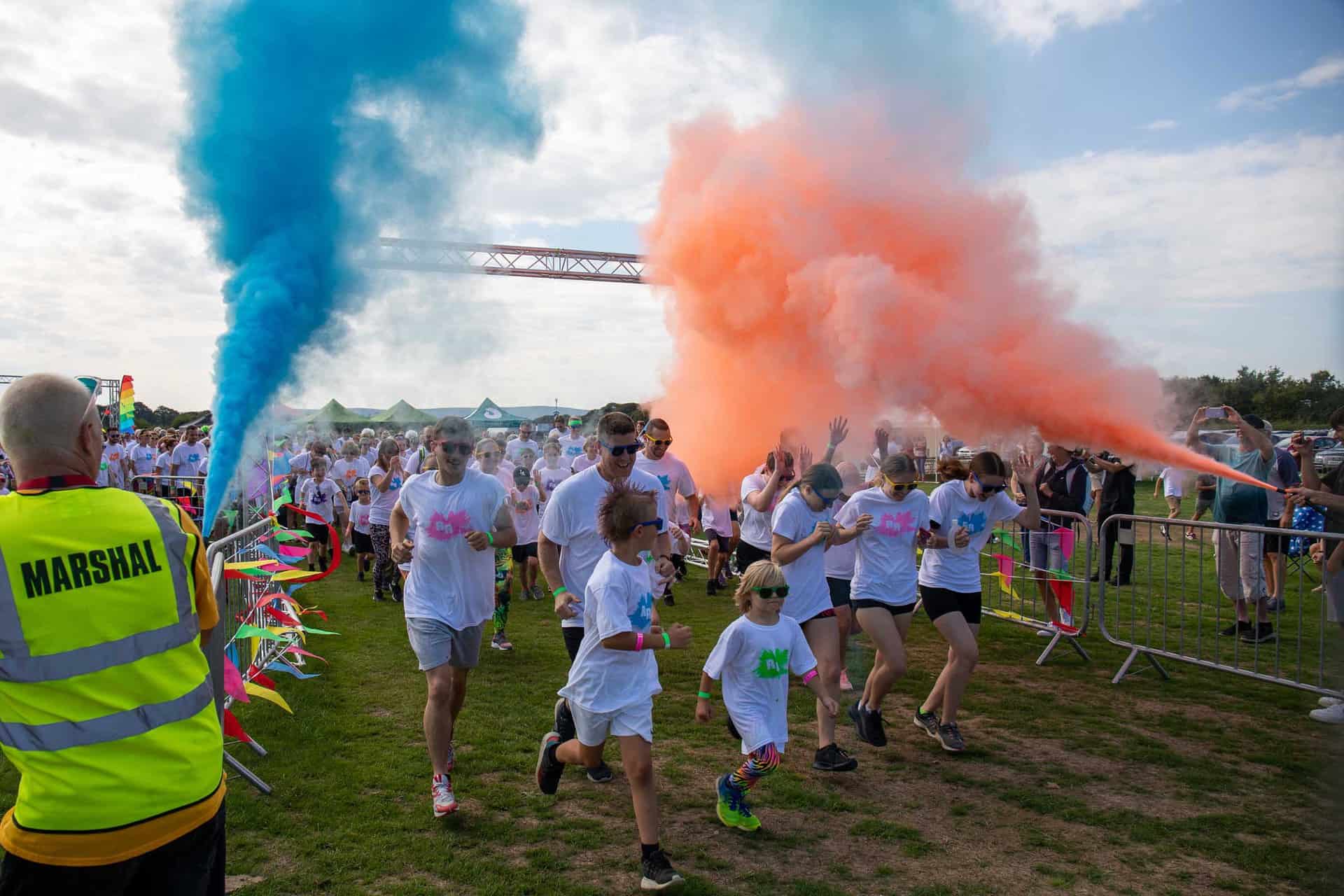 Rainbow Runners running through orange and blue powdered paint