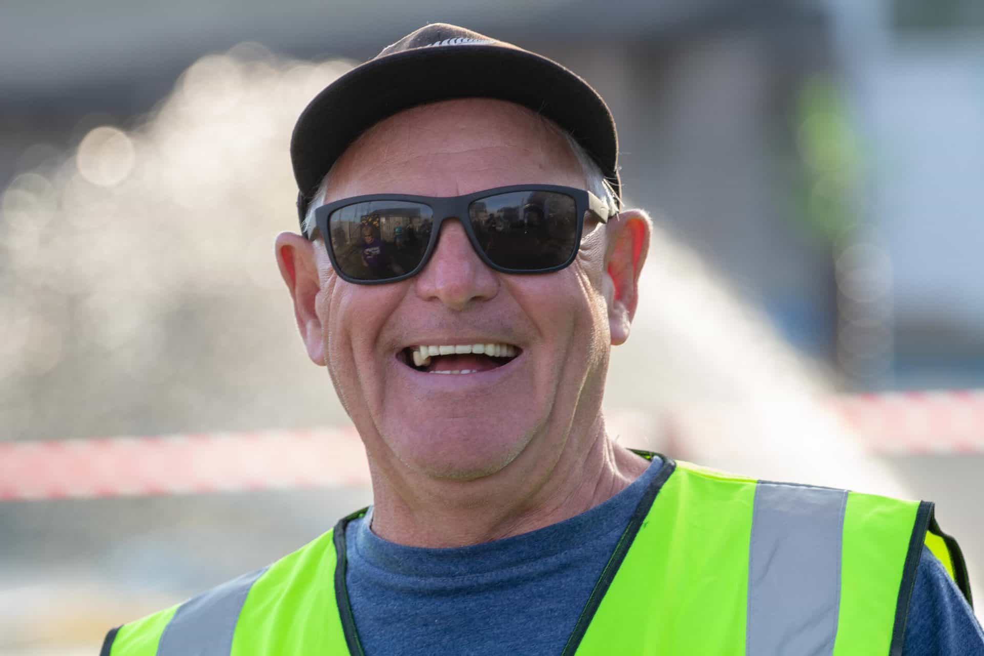 Volunteer in hi-vis jacket smiling at camera