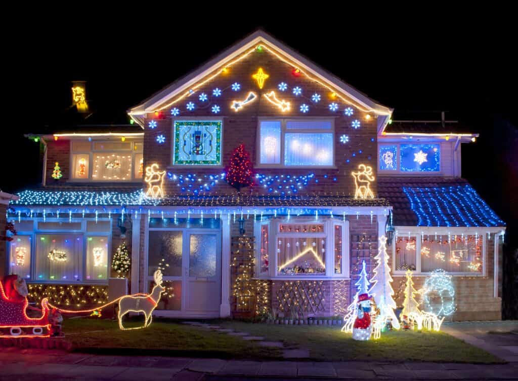 House decorated in colourful Christmas Lights, including a santa, reindeer and snowmen