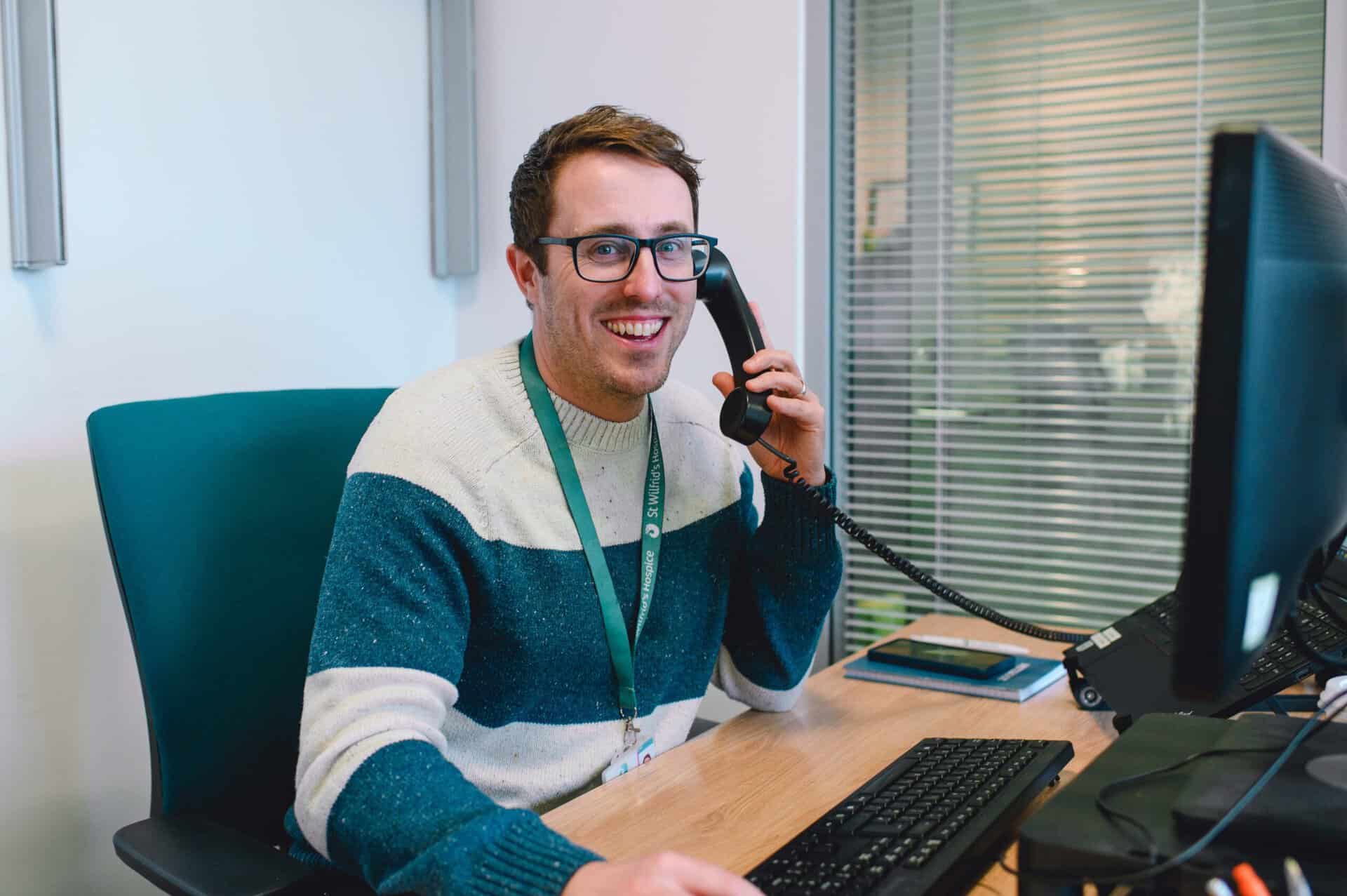 man at a desk using the telephone
