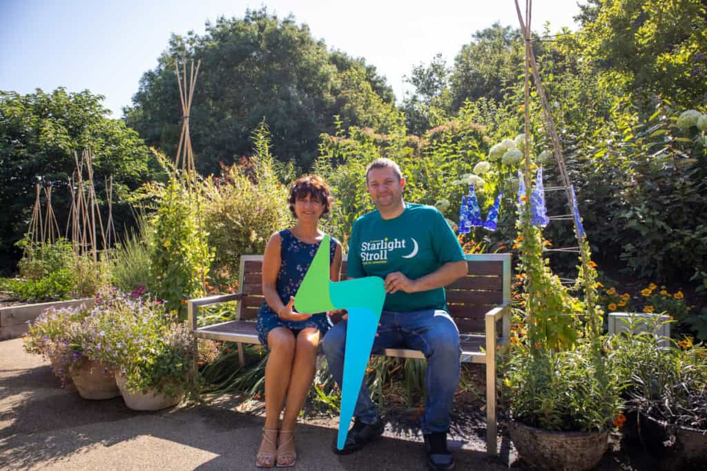 Man and woman holding logo